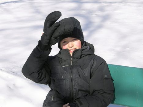 picture of a young boy ice skating in a city park in winter