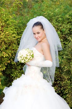 a bride with a flower bouquet looks playfully