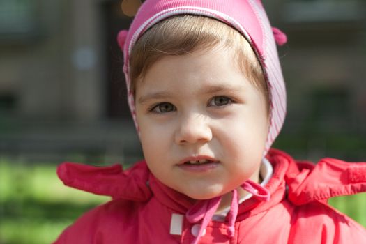 little girl in a red jacket, on the street