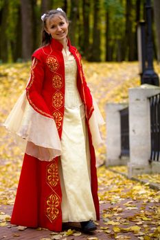 lady in medieval red dress in the autumn forest
