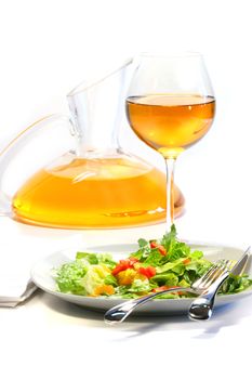 Plate of salad and wine glass on white background