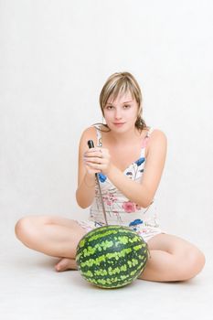 girl holds a knife above a water-melon
