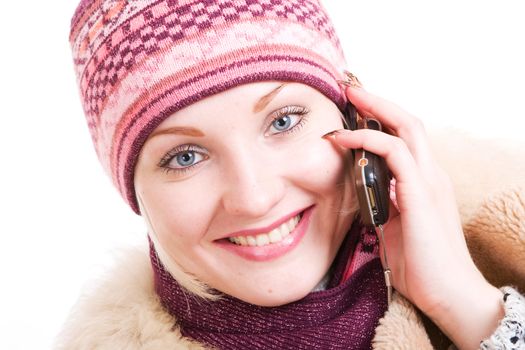 a wide smiling young Woman dressed in winter clothes talking a mobile phone