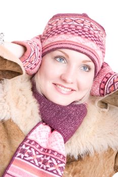 a smiling girl dressed in winter cap, coat, mittens and scarf looks up