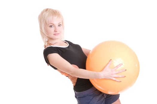 young woman with a big yellow ball in her hands goes in for fitness