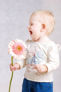 small girl laughing with flower in hands