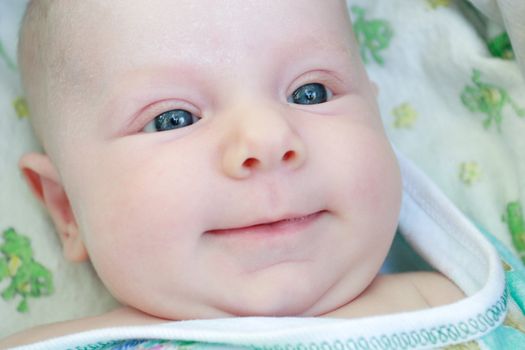 a face of a smiling baby of 2 months old