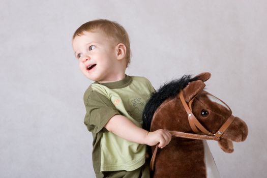 laughing boy sitting on a toy horse