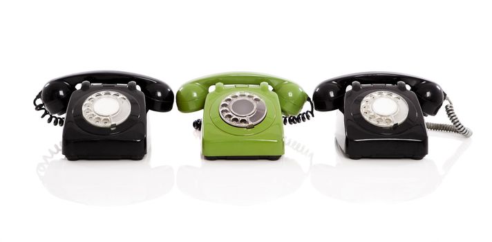 Green phone in the midle of two black phones, isolated on white background