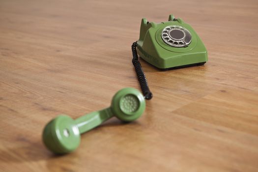 Vintage green phone over a wood floor