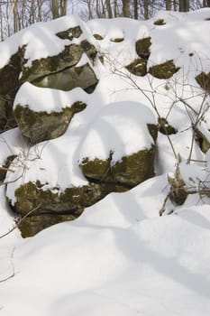 Rocks under snow in sunny winter day