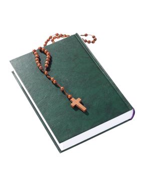 wooden rosary on the Bible, isolated on white