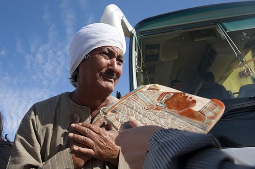 LUXOR - JAN 29: Egyptian peddler selling wares to the tourists outside Luxor temple.Jan 29,2013 in Luxor,Egypt.