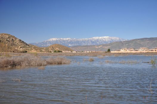 Snow-capped Mount San Gorgonio is seen in the distance beyond this pond in Hemet, California.