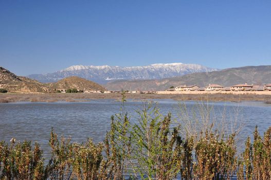 Snow-capped Mount San Gorgonio is seen in the distance beyond this pond in Hemet, California.