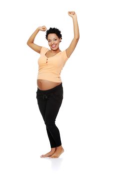 Full lenght picture of a smiling young pregnant woman stretching her body, isolated on a white background.