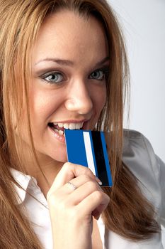 Young and beautiful girl with a credit card in the hands of blue