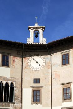 Ancient building with clock and bell tower against blue sky