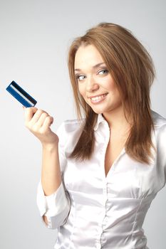 Young and beautiful girl with a credit card in the hands of blue