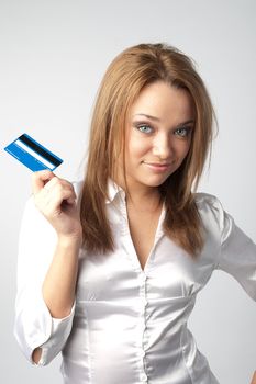 Young and beautiful girl with a credit card in the hands of blue