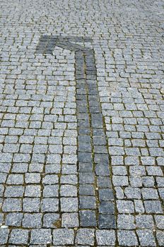 cobbled road with arrow as background