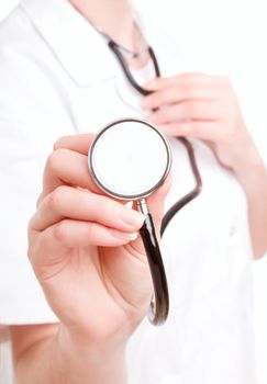 Female doctor holding stethoscope pointed toward camera 