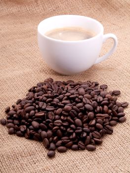 Coffee beans with cup on canvas 