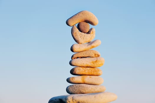 Stack of pebbles balancing on a sky background