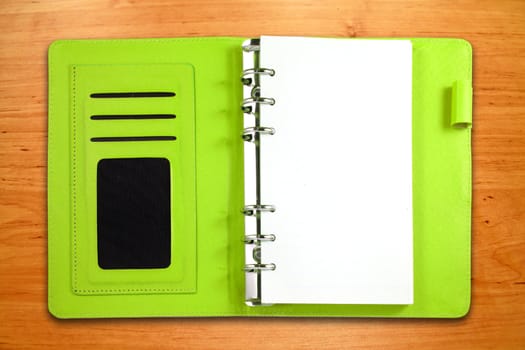 Green leather binder notebook on wooden background