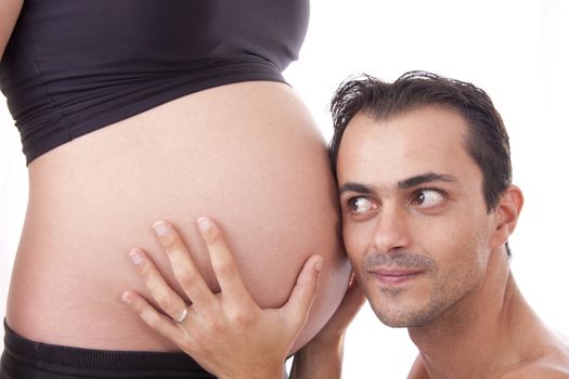 husband listening to the heartbeat of the baby