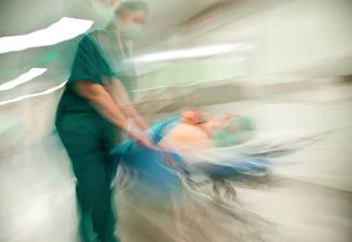 Blurred figures of nurse with medical uniform moving patient on trolley