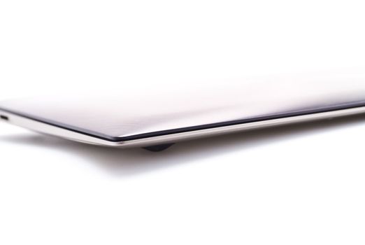 a modern metal laptop with closed lid on white background for abstract background