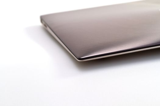 a modern metal laptop with closed lid on white background for abstract background