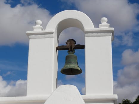 Close up photo of a bell on a white building