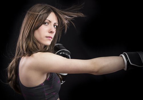 boxer woman during boxing exercise making direct hit with black gloves