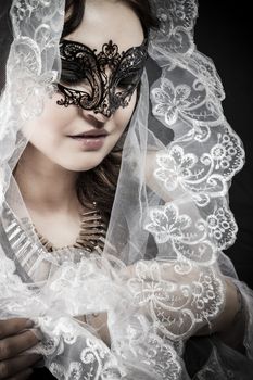 Virgin, Woman in veil and black dress with venetian mask, glamour scene