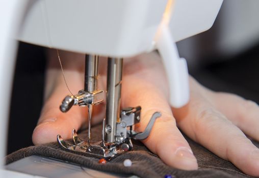 Woman hands sewing on the stitching machine.