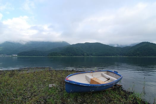 summer morning landscape with blue boat on the lake's shore, Lake Kawaguchi, Japan
