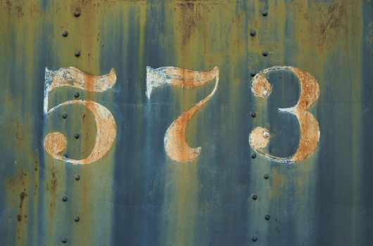 Detail image of the number 573 on the side of a steam powered locomotie engine.