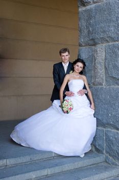 groom embrases bride on the staircase