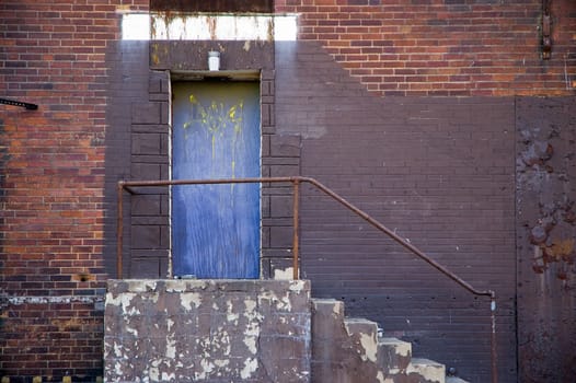 Blue back door at the rear of an old city building.