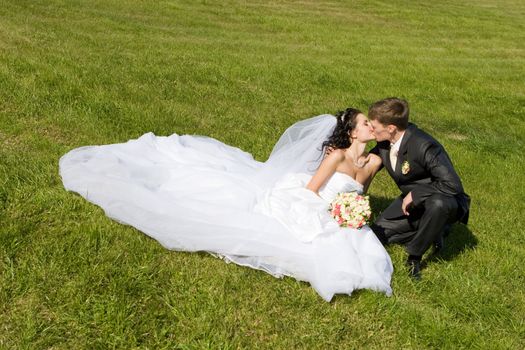 bride and groom kiss in the park