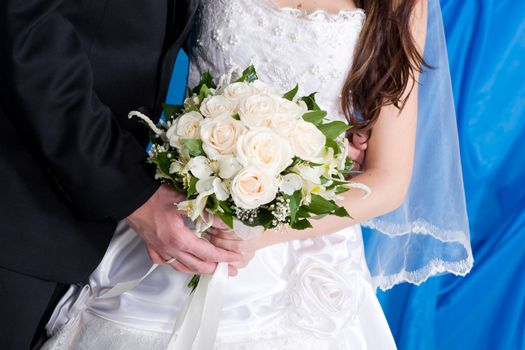 a beautiful white rose bouquet in the hands of the bride and the groom