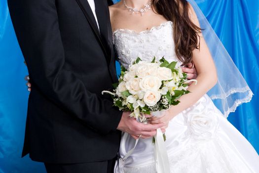 a beautiful white rose bouquet in the hands of the bride and the groom