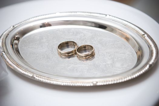 two wedding rings on the decorated plate