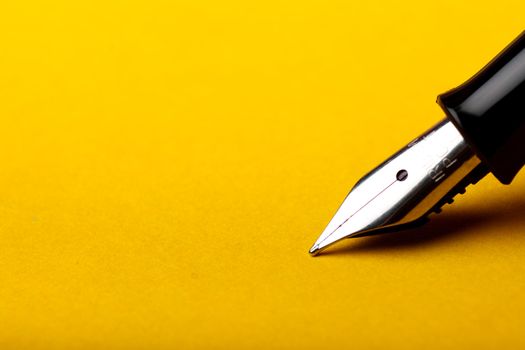 Macro isolated fountain pen on amber background