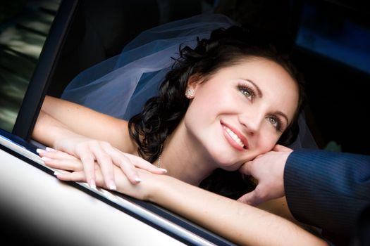 happy bride looks out of the car