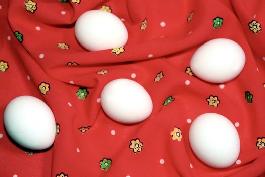 White eggs on the red floral textile