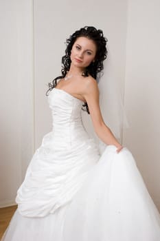 bride in a beautiful dress near the wall