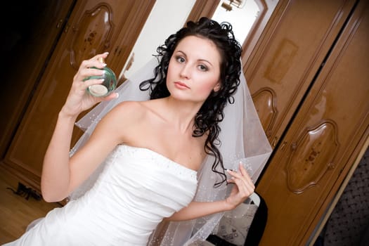 bride at home with a bottle of perfume